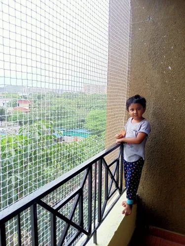 Netting across a home balcony with a child standing nearby