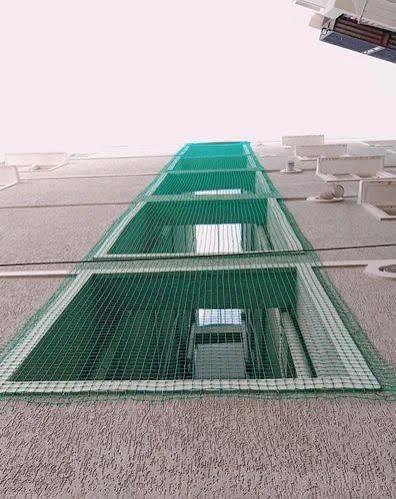 Green netting fitted over a multi-storey building utility opening
